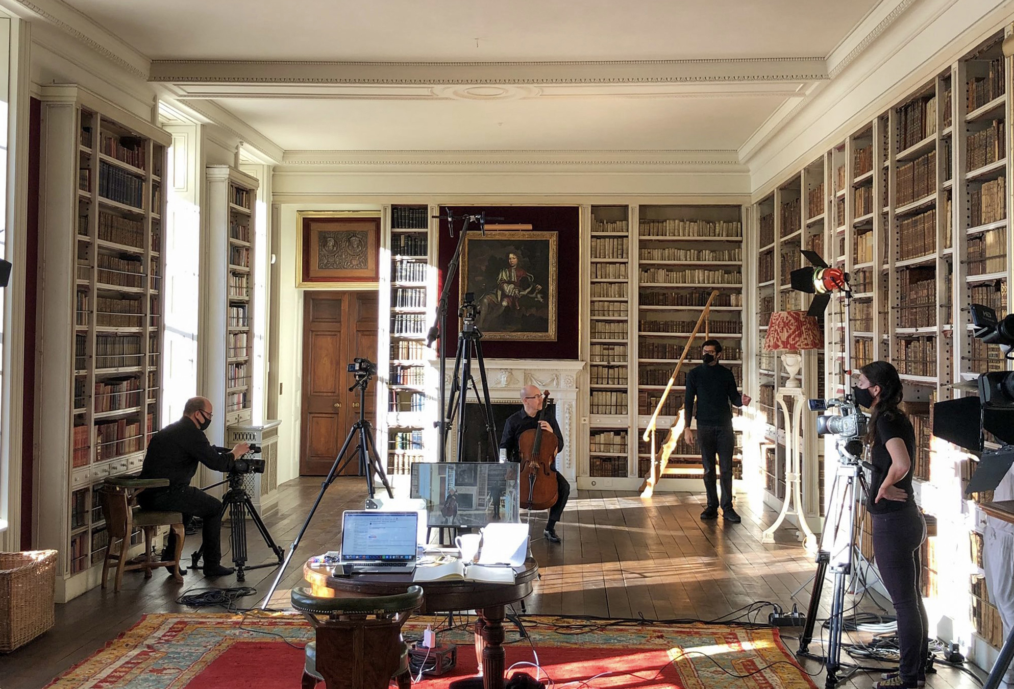A film crew filming a cello performance in a historic house